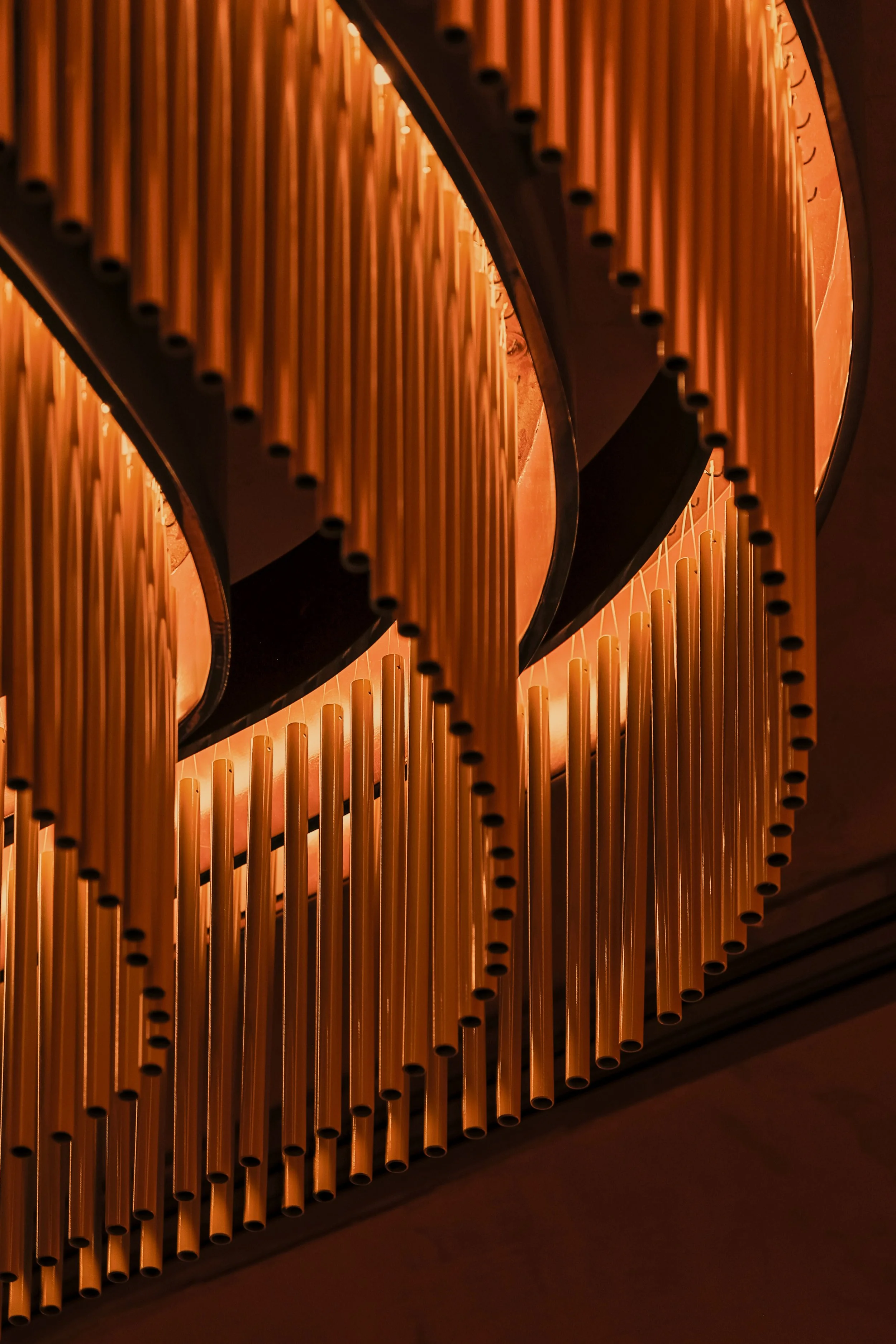Close-up of Mea Culpa’s custom chandelier, composed of layered curved frames and illuminated metal tubes.