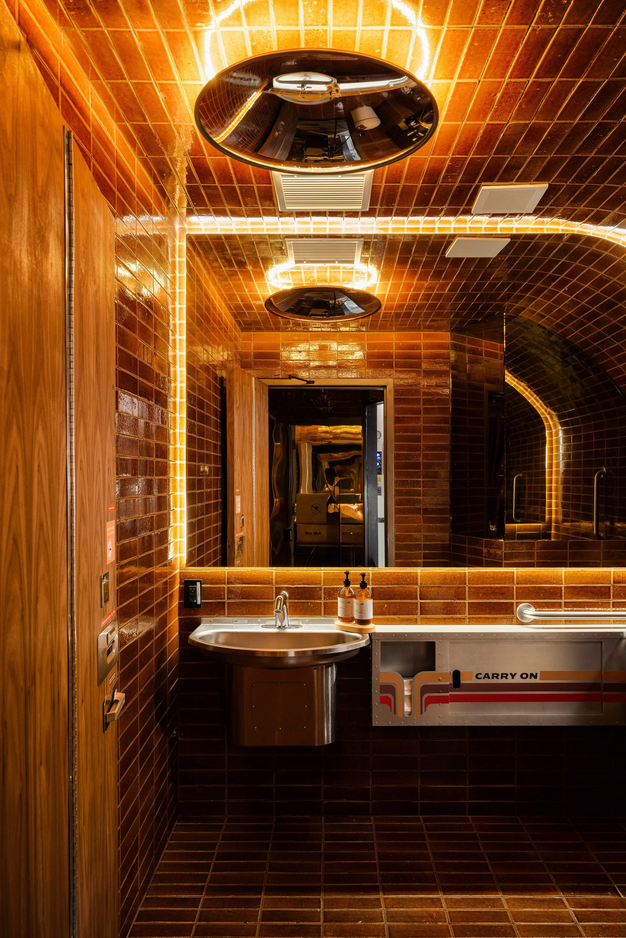 Restroom Interior of Carry On in Downtown Phoenix, an immersive 1970s airline-inspired cocktail bar designed by Peter Bowden of PETERMAX Co.