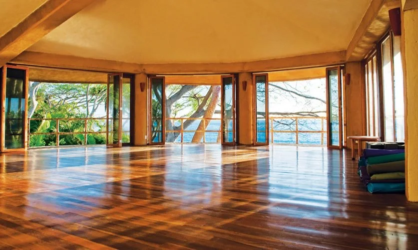 Studio space with open windows overlooking the ocean.