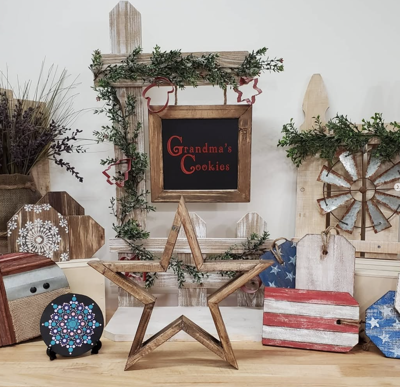 Decorative shelves and signs with rustic and holiday-themed decorations, including greenery, a star-shaped wood frame, and a sign reading 'Grandma's Cookies'.