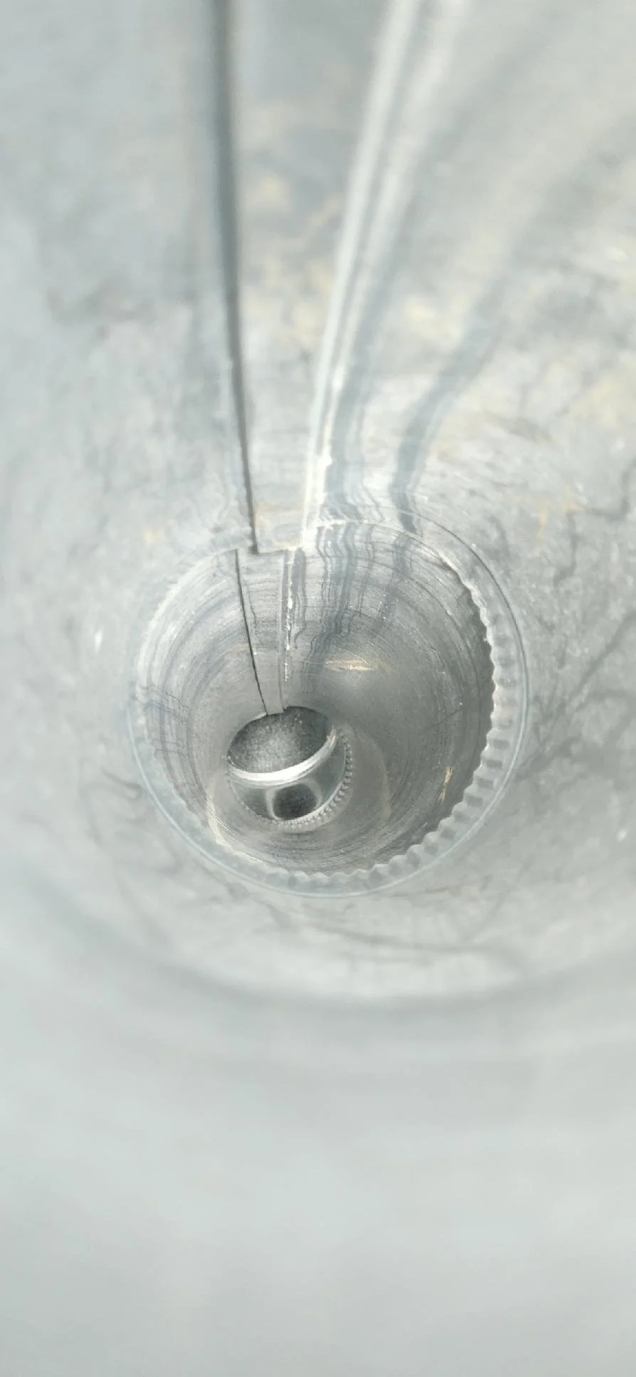 Inside a metallic cylinder or tube showing post dryer vent cleaning and how clean and shiny the cylinder now is.