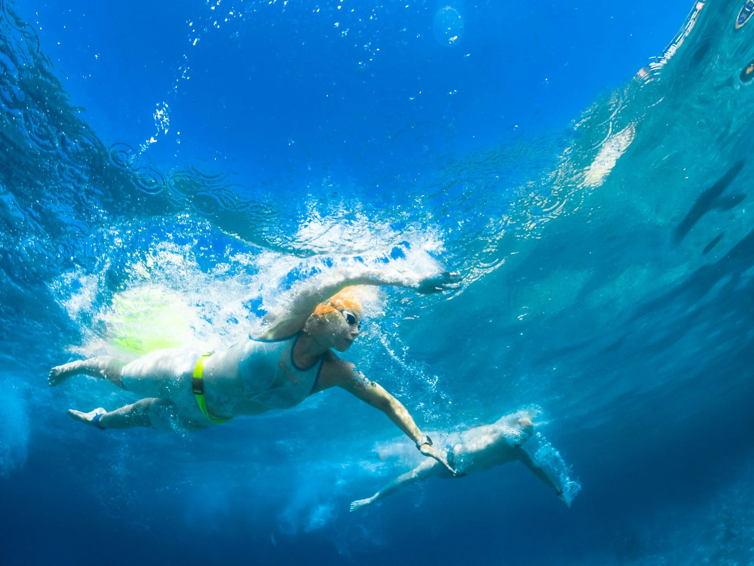 Athlete swimming in open water with visibility buoy and belt