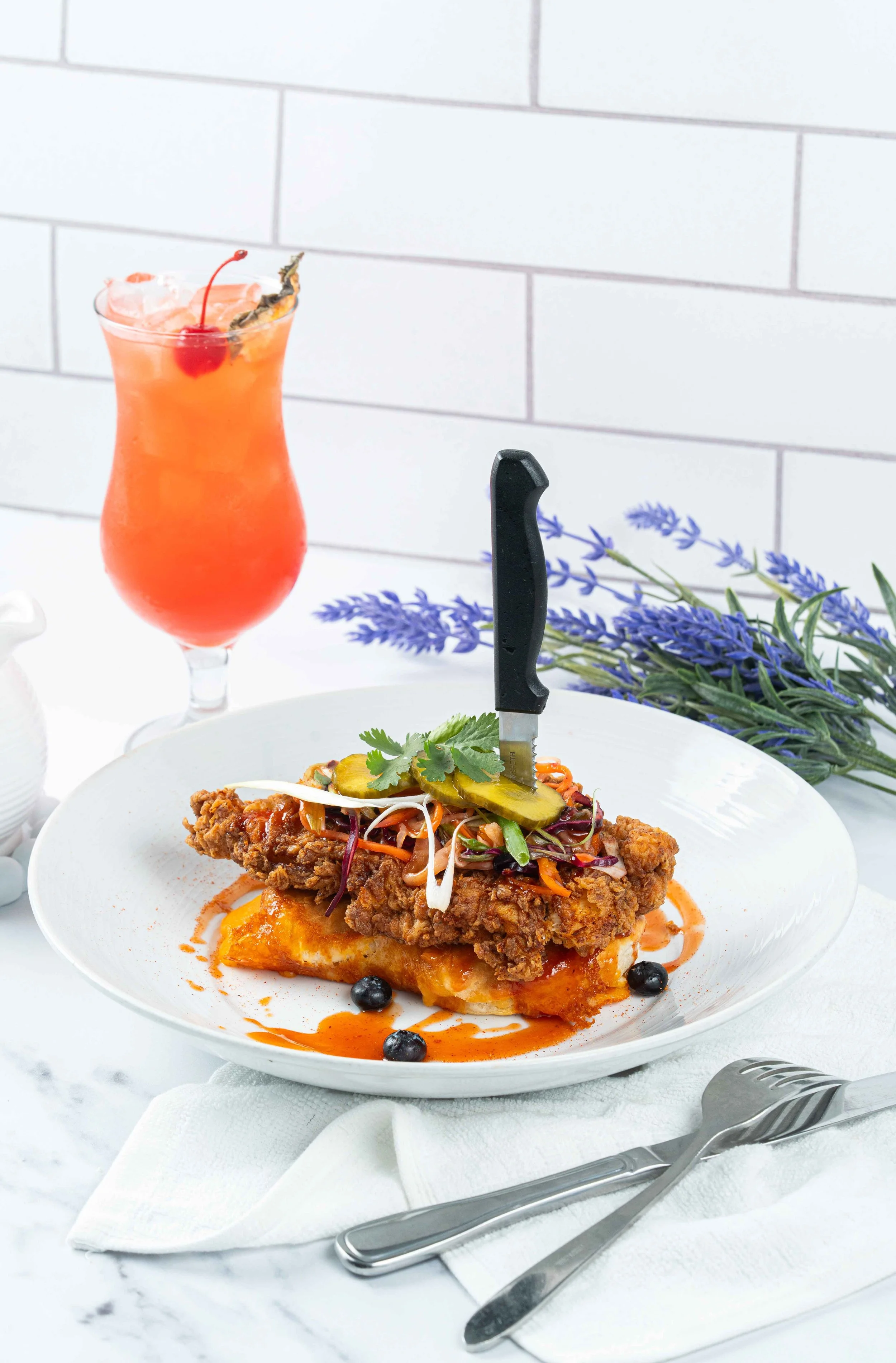 Fried chicken with buttermilk biscuit in front of  a glass of red sangria