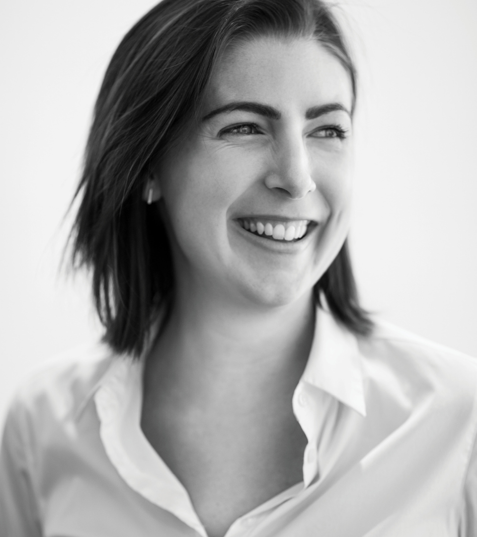 Black and white portrait of a woman smiling, wearing a collared shirt.