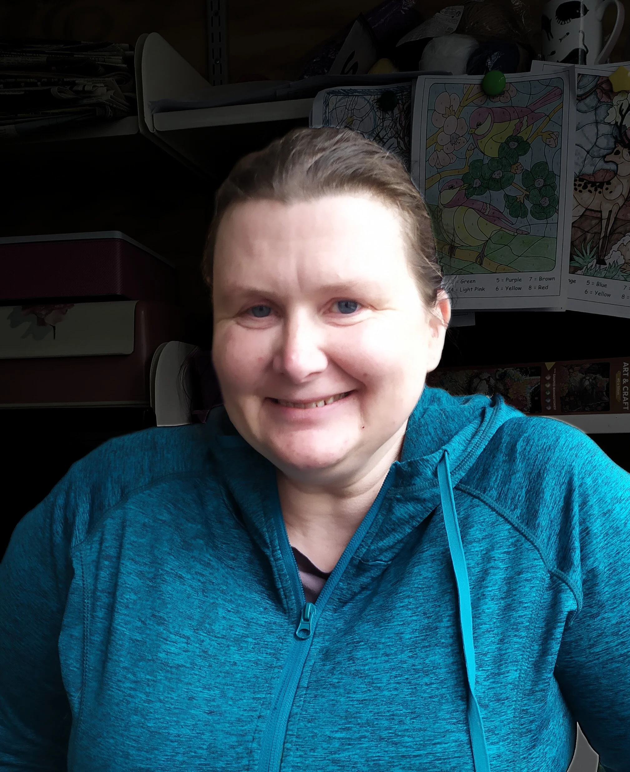 A white woman in ski gear on a snowy ground with mountains in the background 