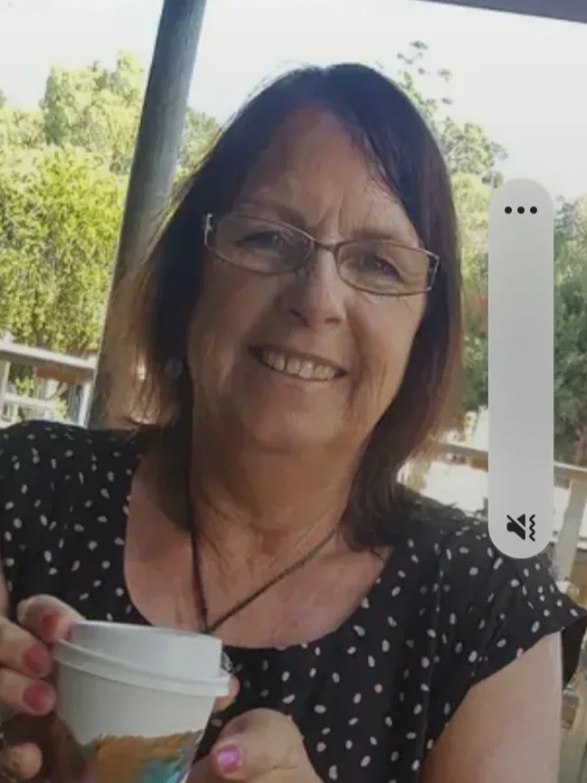 A close up of a smiling white woman with brown hair and glasses