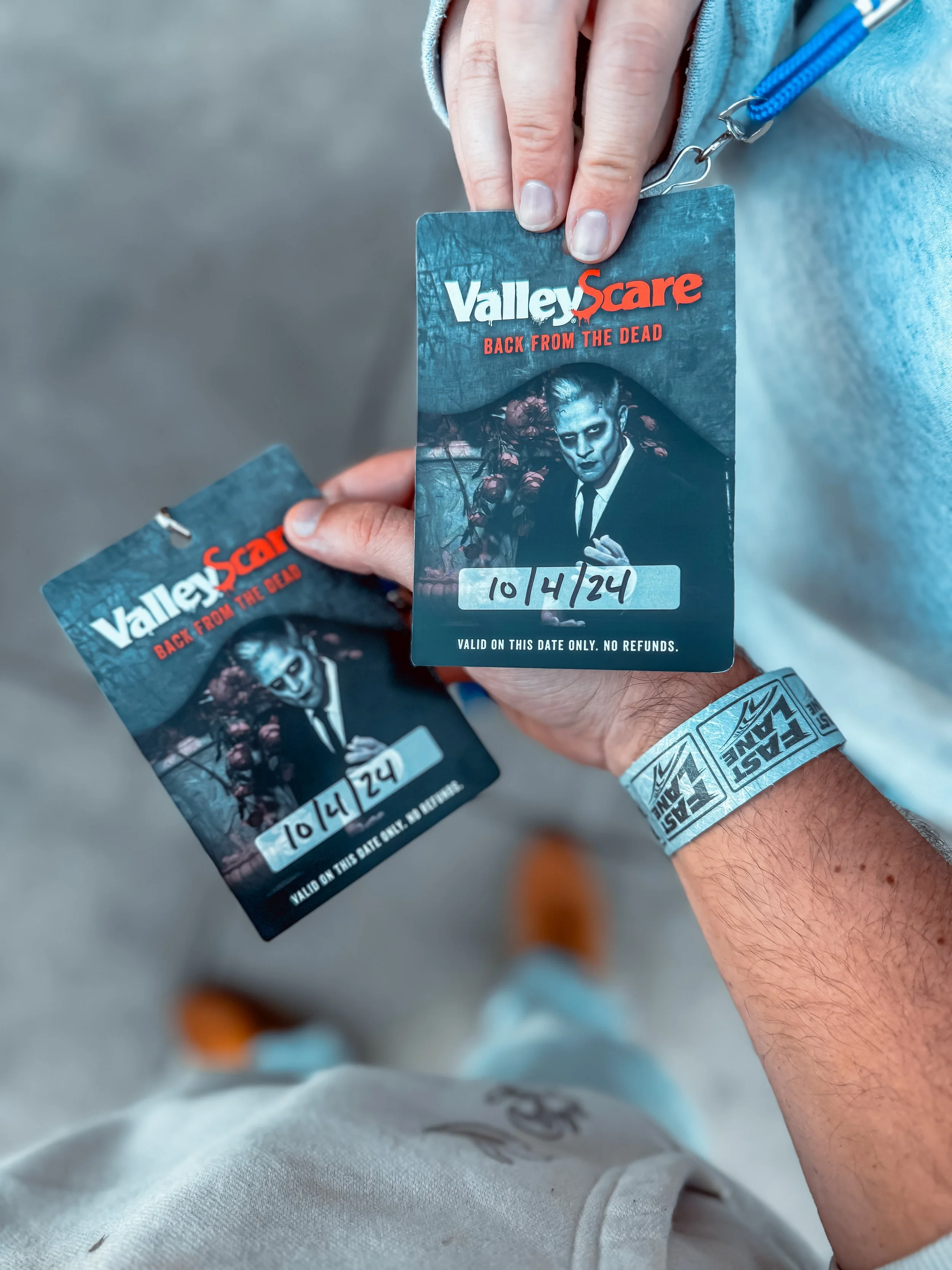 Person holding two ValleyScare tickets with the theme 'Back From The Dead' featuring a zombie-like figure in a dark setting, both tickets show the date 10/4/24.