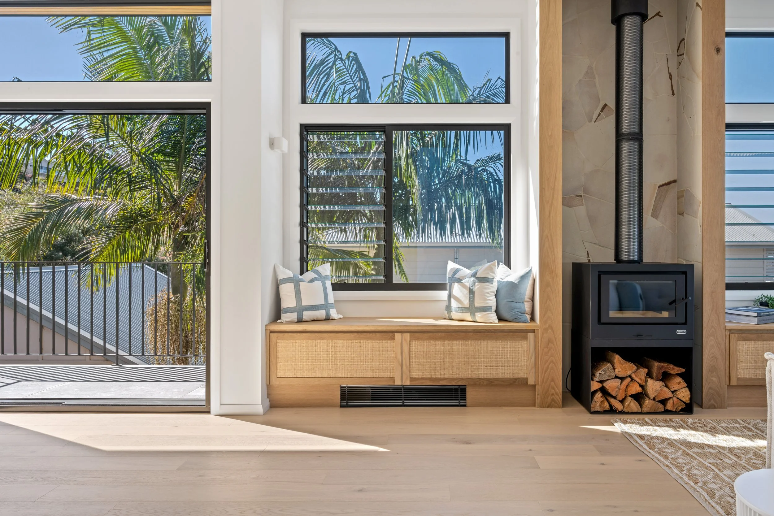 Window bench and mid-century modern fireplace in bright living room