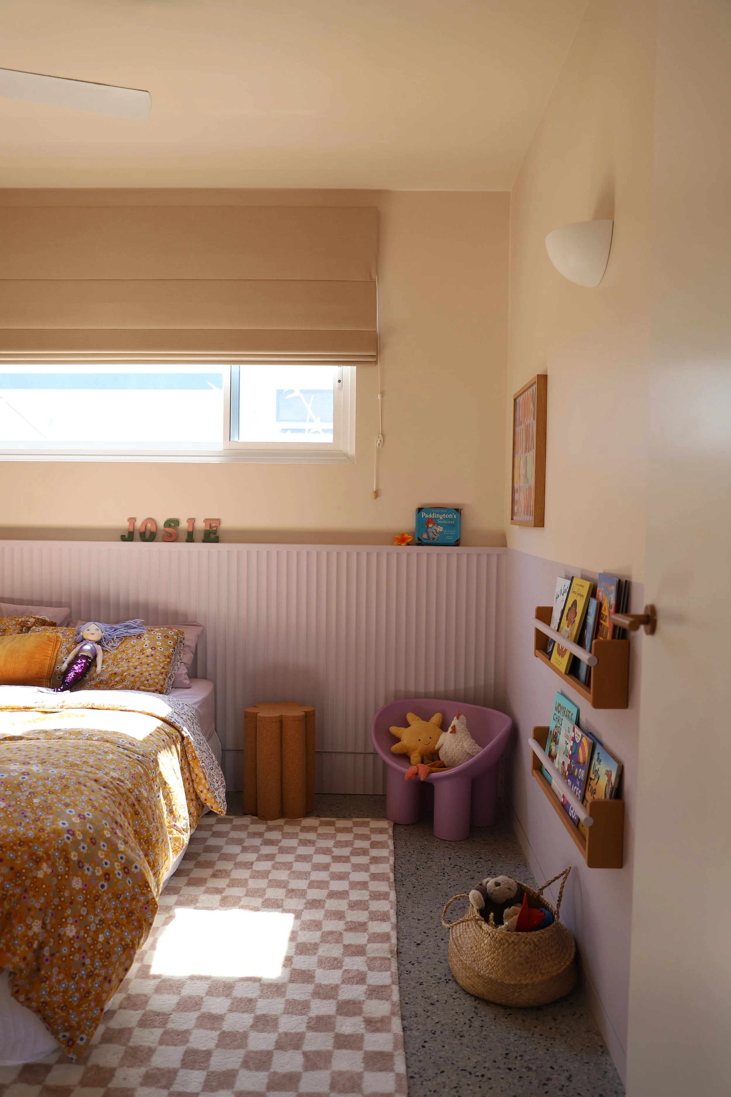 Corner shot of children's bedroom with lilac half wall and colourful fittings