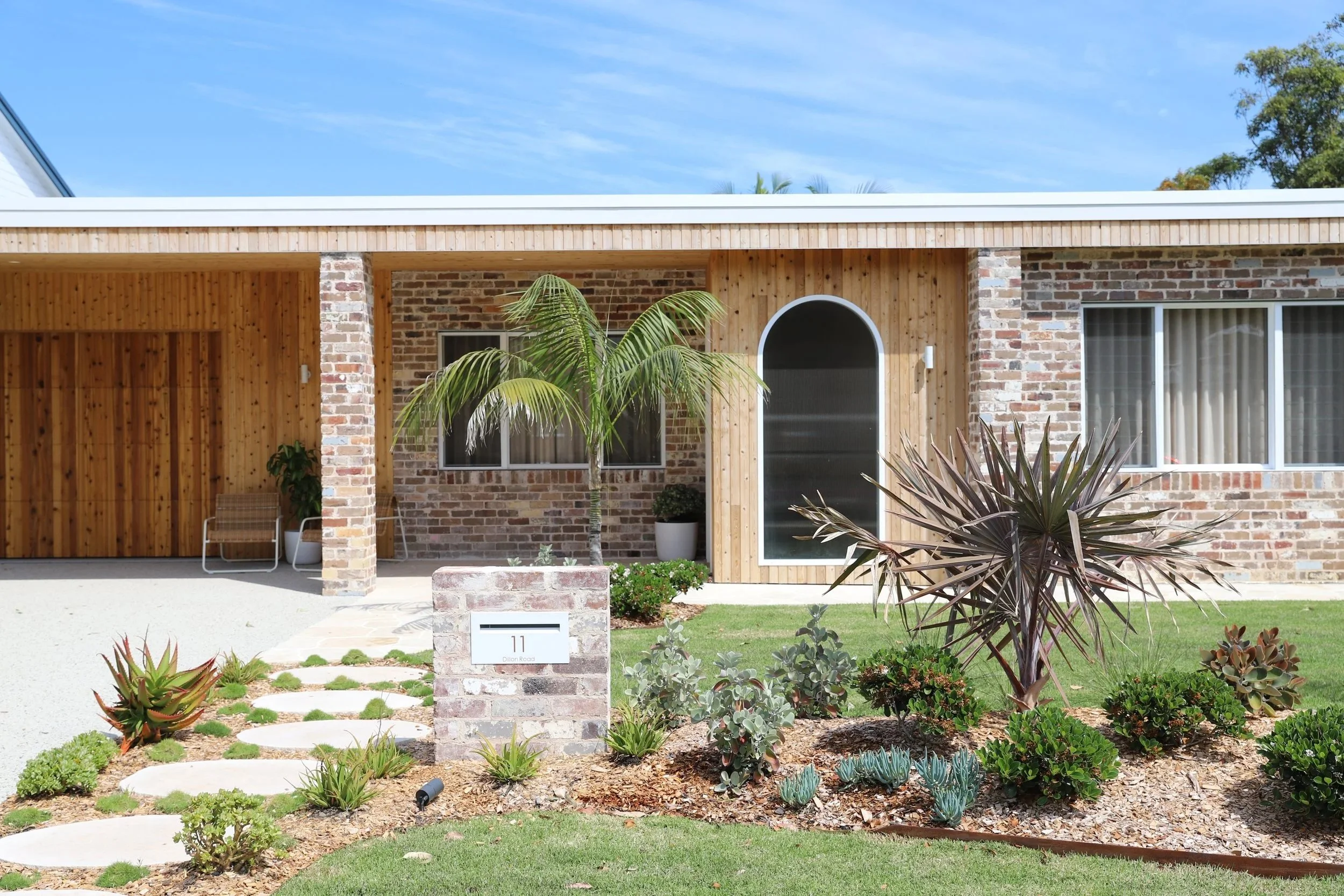 Single story brick and timber house with landscaped front yard
