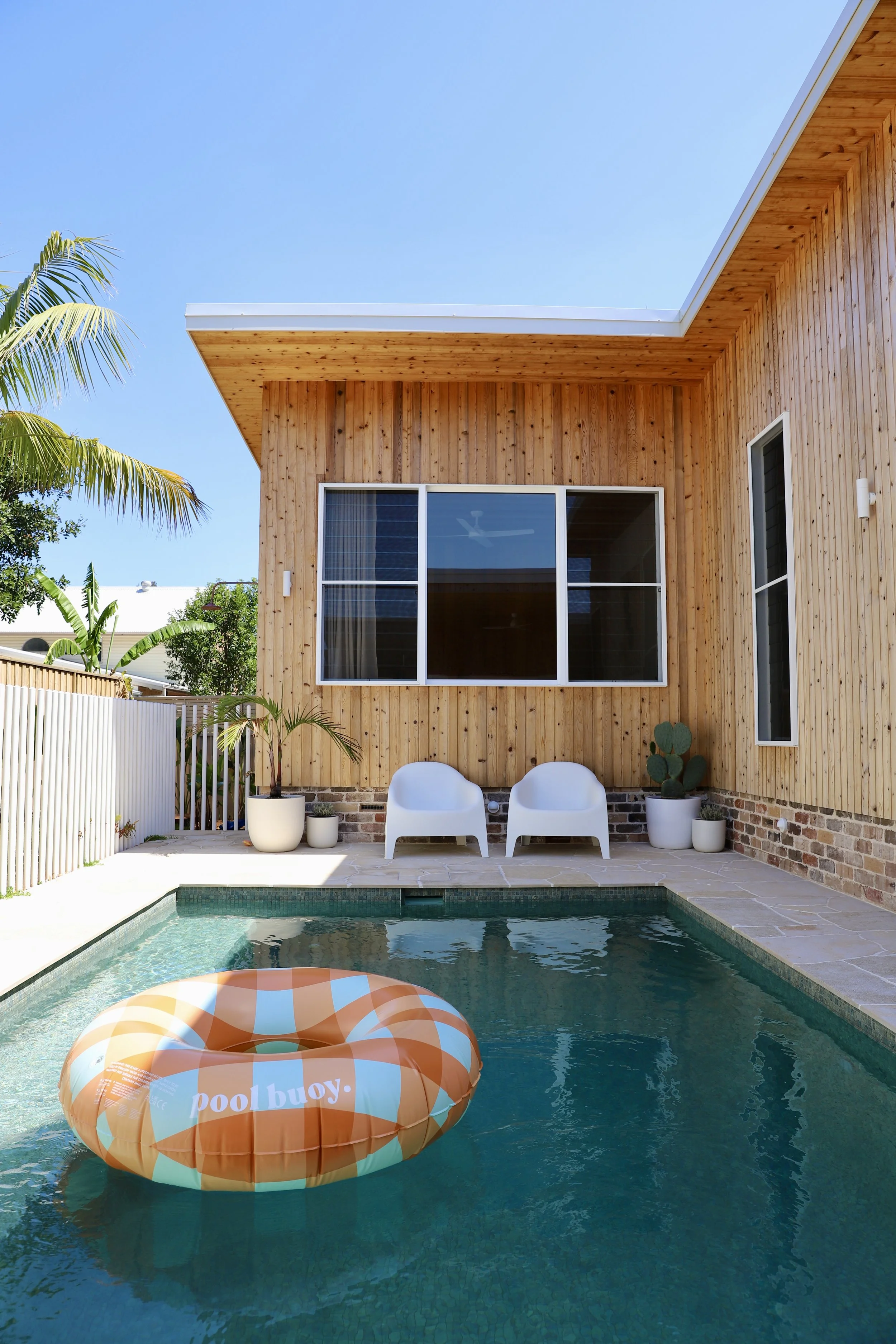 Exterior plunge pool with orange pool floaty and outdoor seating