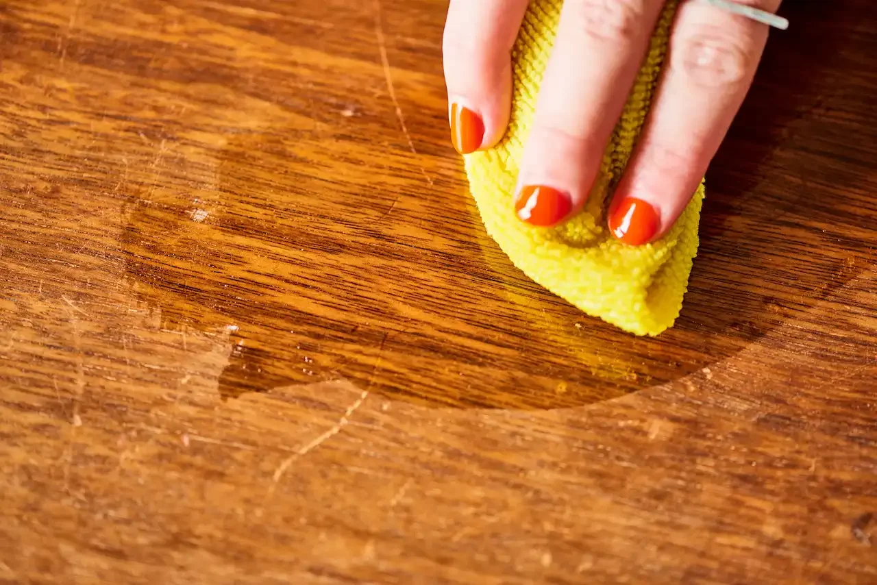 cleaning light scratches on wooden furniture with a cloth