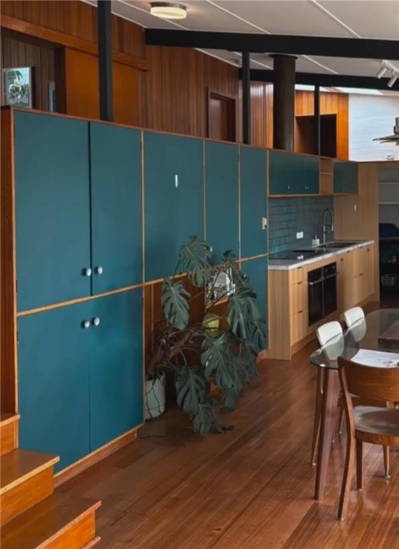 Mid-century home interior with timber and blue cabinetry