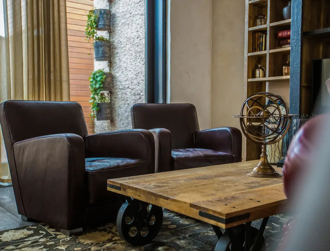 Cozy living room with two brown leather armchairs and a wooden coffee table with decorative globe.