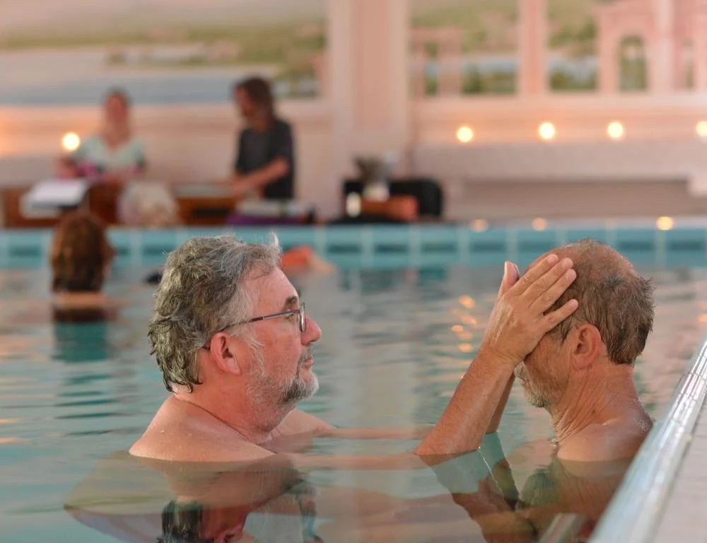 Ein Watsu-Schüler des Aquamunda Instituts bei der Watsu-Abschluss-Sequenz in atmosphärischer Stimmung während der Aquatischen Nacht.