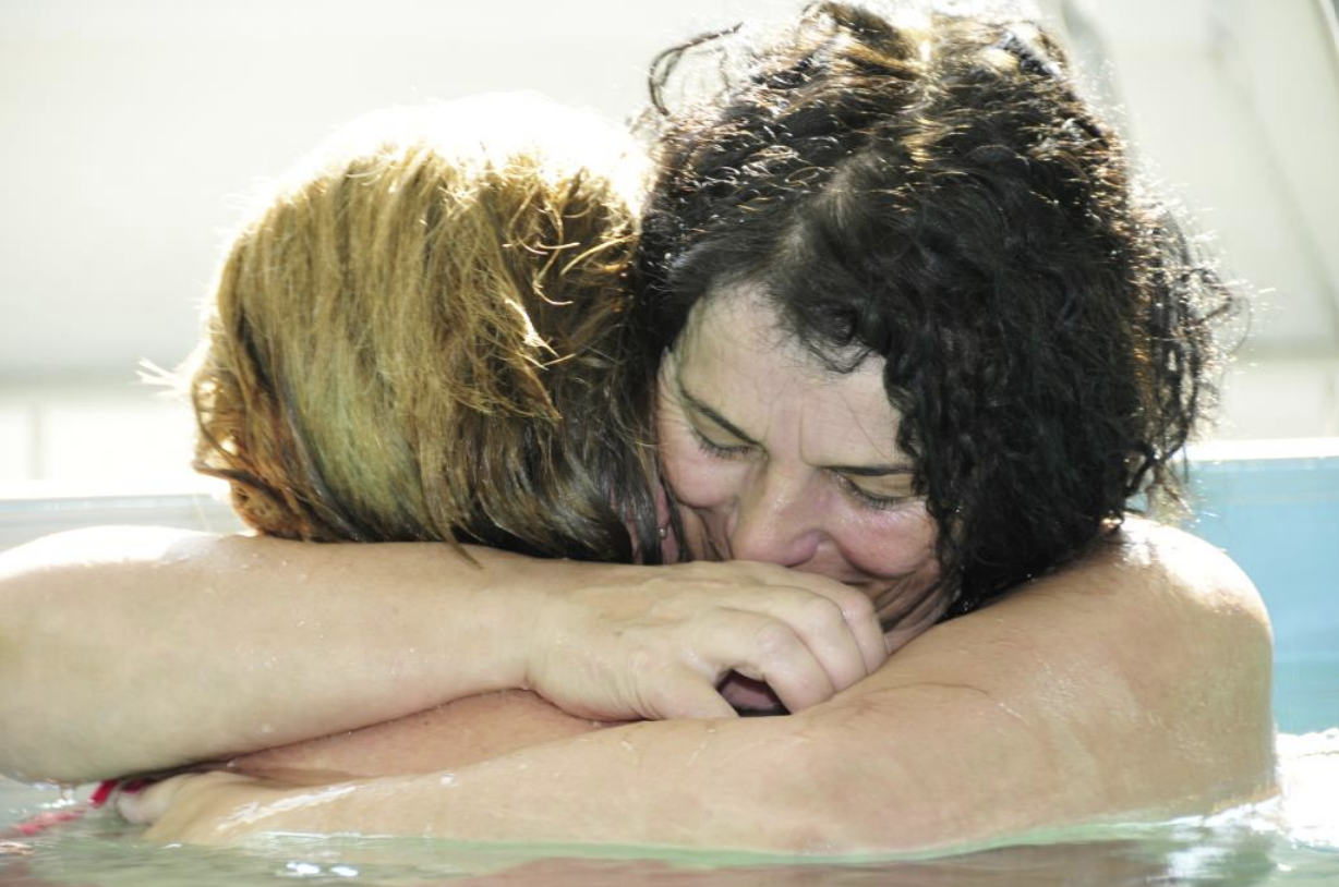 Zwei Frauen umarmen sich nach einer berührenden WATSU-Session