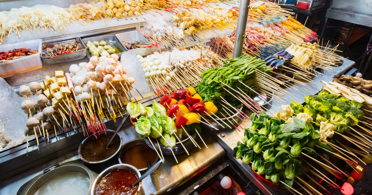 A Malaysian lok lok stall displaying skewered seafood, vegetables and tofu at a night market