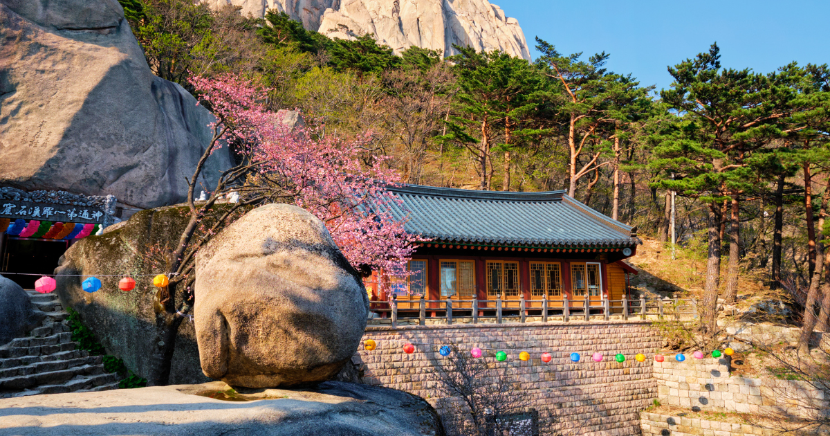 Traditional Korean temple building beneath Ulsanbawi Rock in Seoraksan National Park in spring