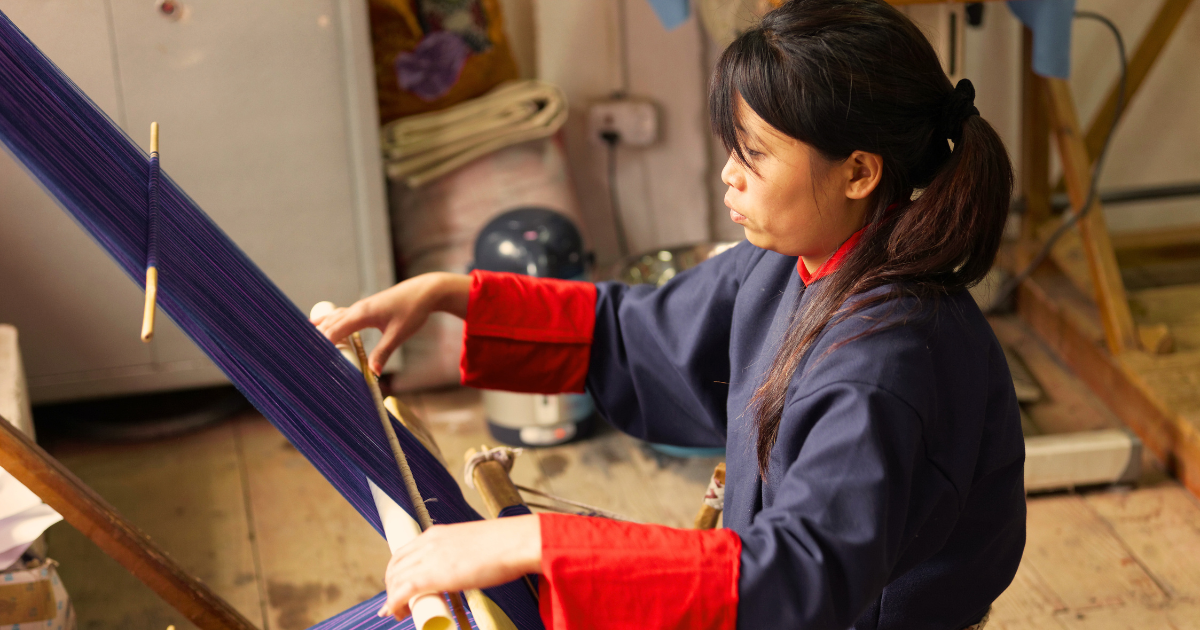 Close-up of a Bhutanese weaver working at a back strap loom
