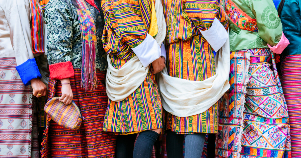 Bhutanese people wearing handwoven ghos and kiras at a gathering