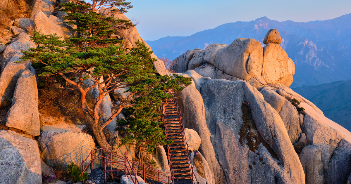 Metal stairways rising through exposed granite on the upper section of the Ulsanbawi hike at dusk