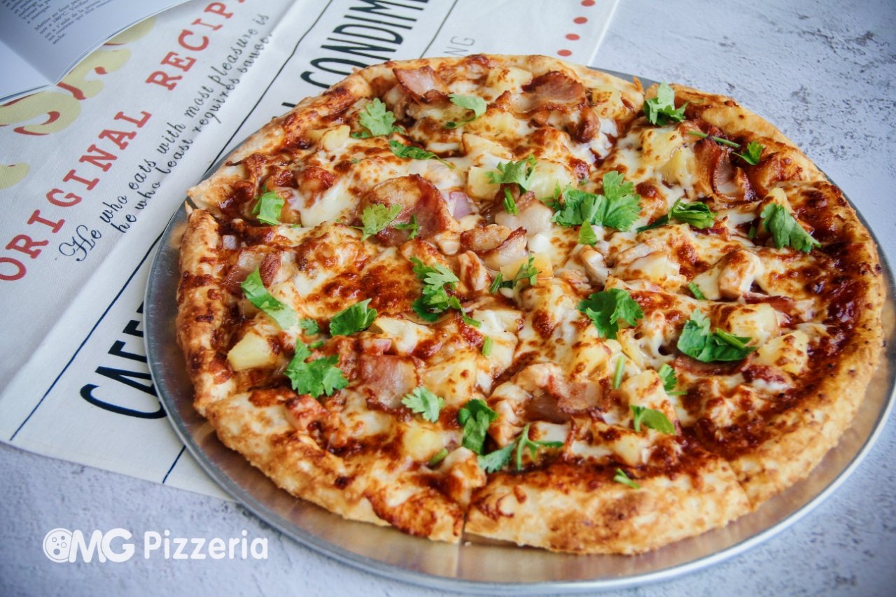 Cheese pizza topped with cilantro on a metal tray, with a pizza restaurant paper underneath.