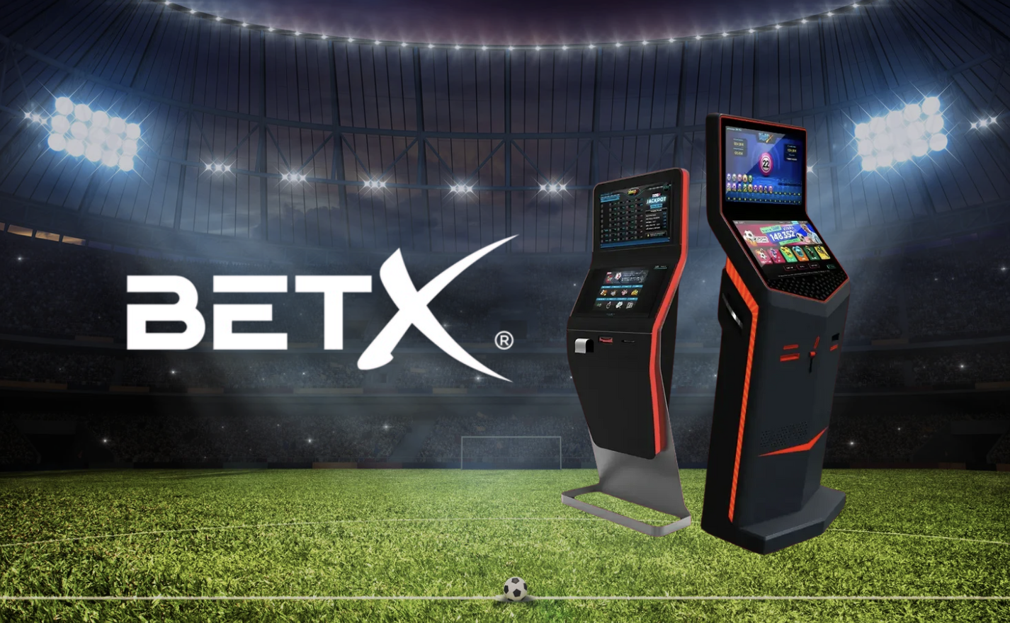 Two electronic gaming machines on a grassy field inside a large sports stadium with bright floodlights and the BETX logo.