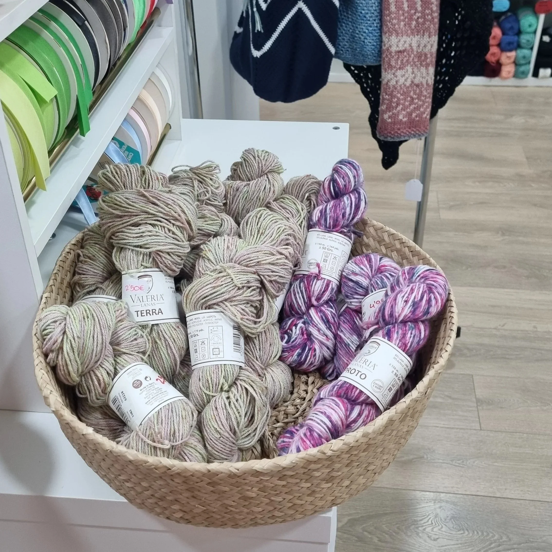 Beige and Pink coloured skeins of knitting yarn sit in a basket