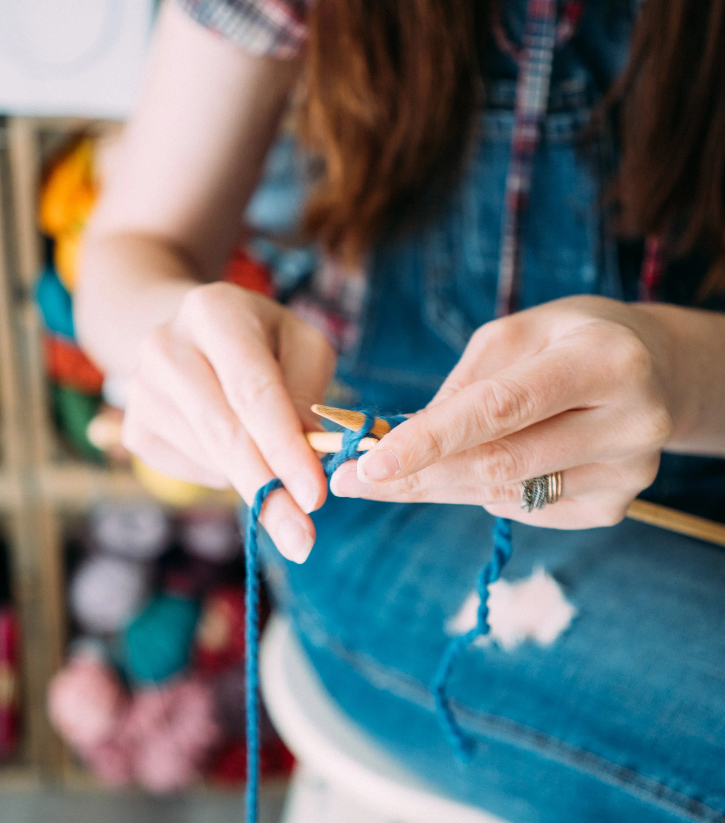 Knitting Teacher Alice's hands knit with blue yarn and wooden needles
