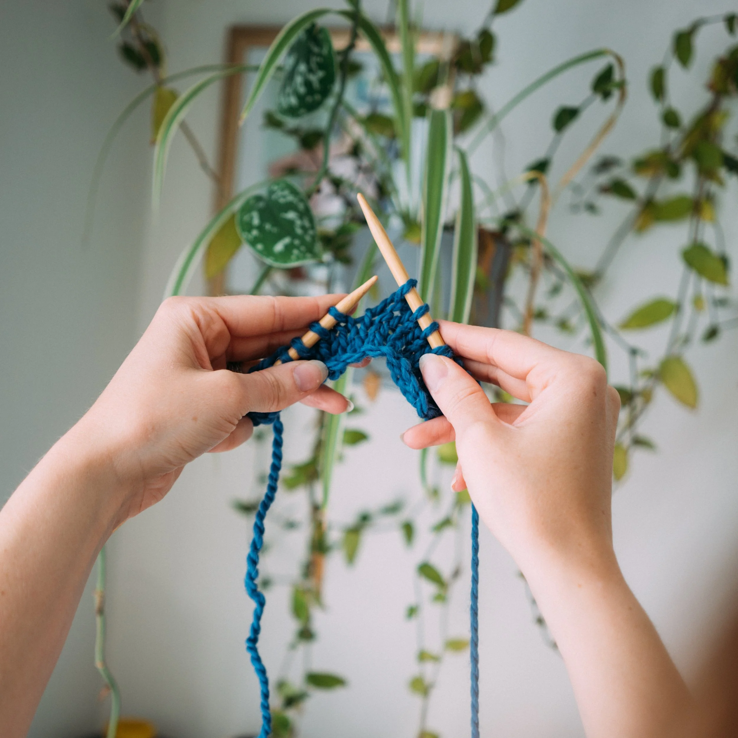 Knitting Teacher Alice hold a hand-knitted yellow sock