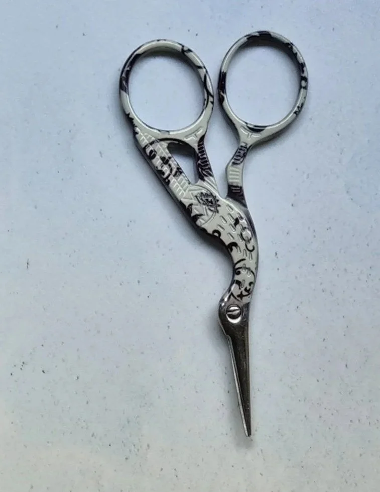A pair of small black and white craft scissors