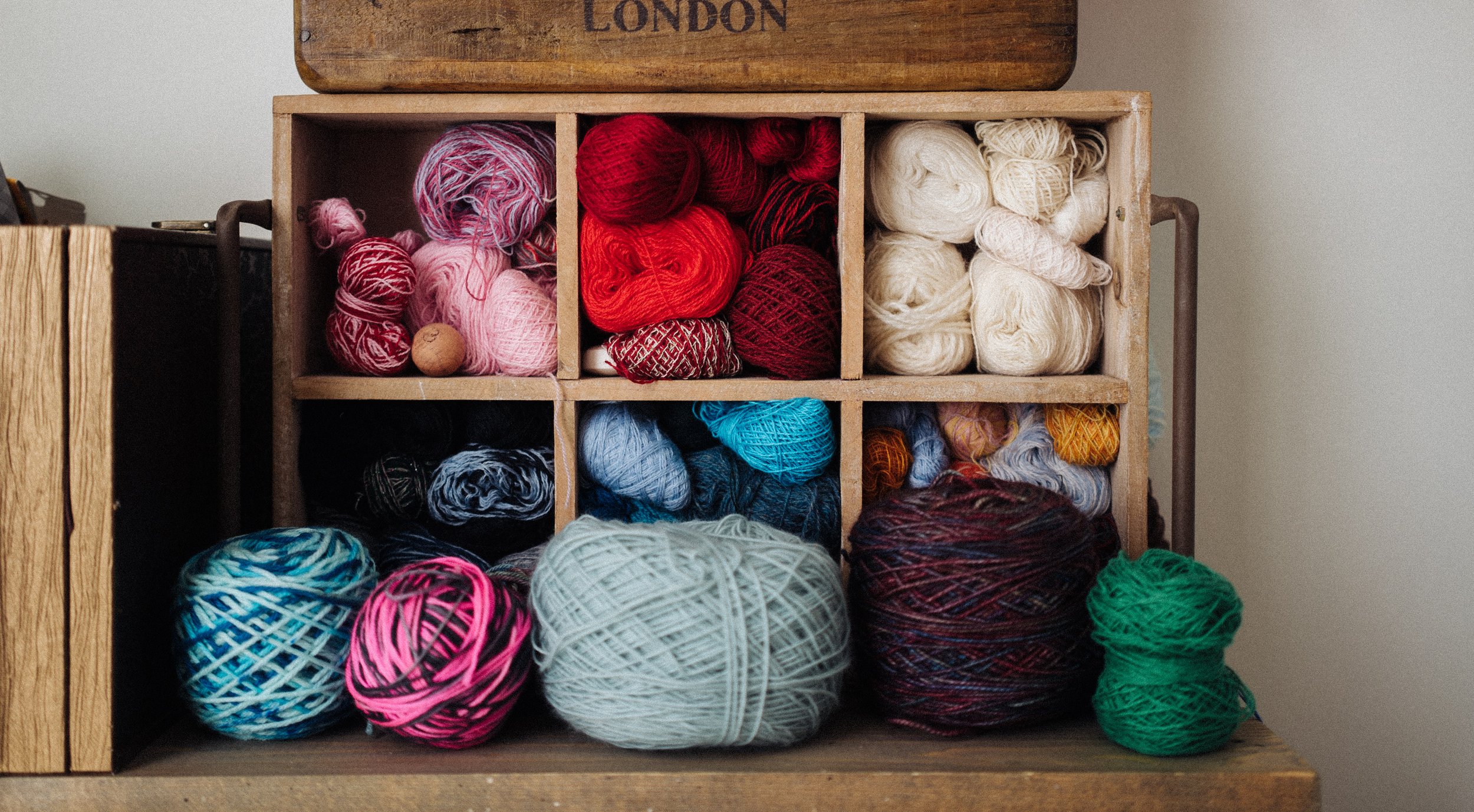 Wound Knitting Yarn sits on a wooden ledge