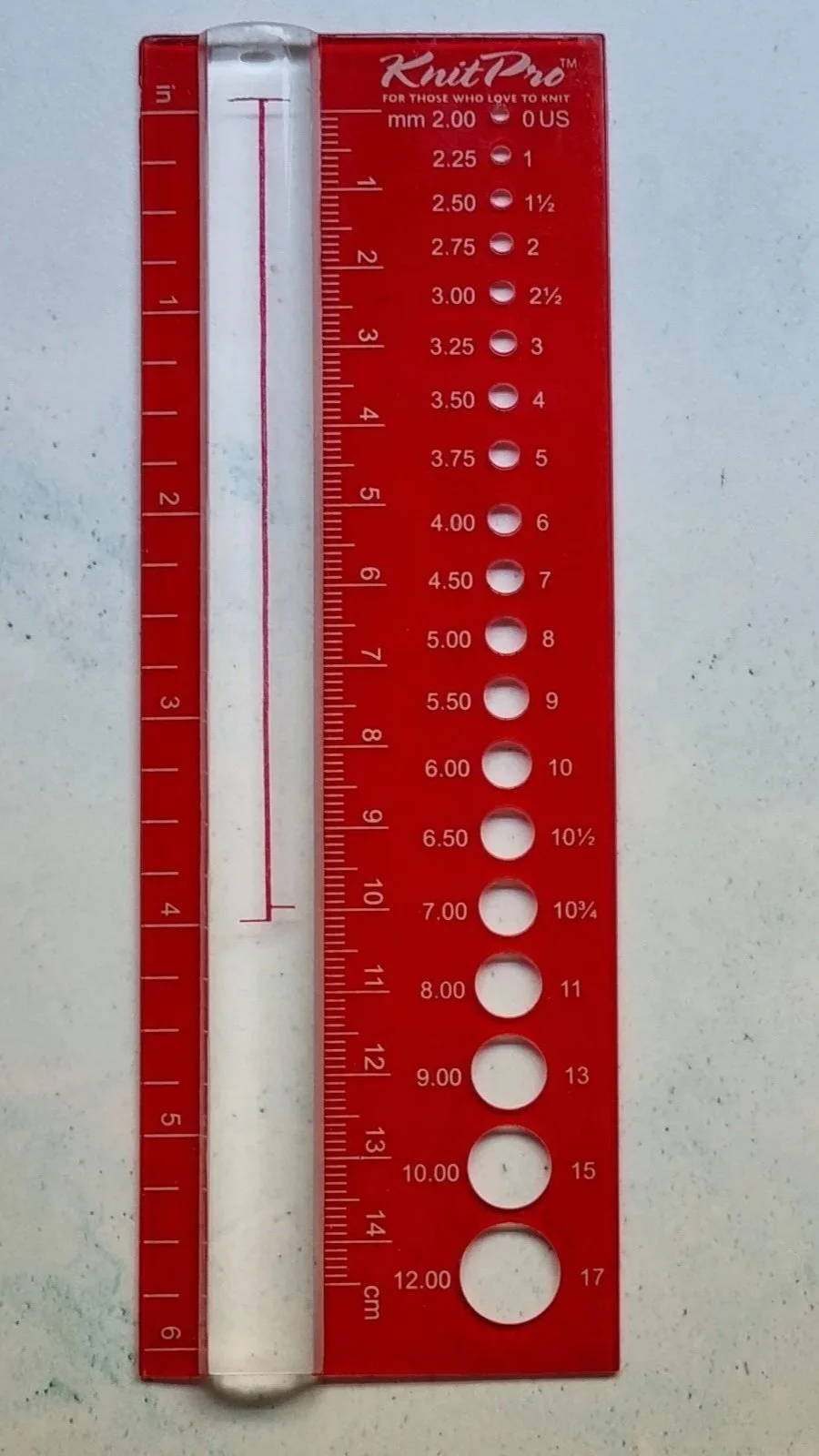 A red plastic knitting needle gauge