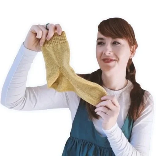 Knitting Teacher Alice holds a yellow Handknitted Sock up