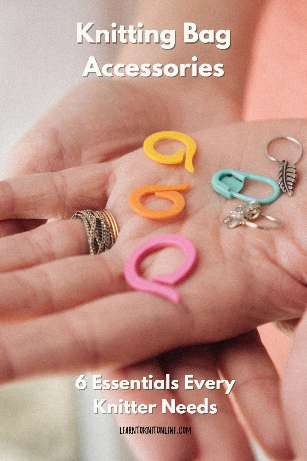 A white female hand holds out a selection of knitting stitch markers