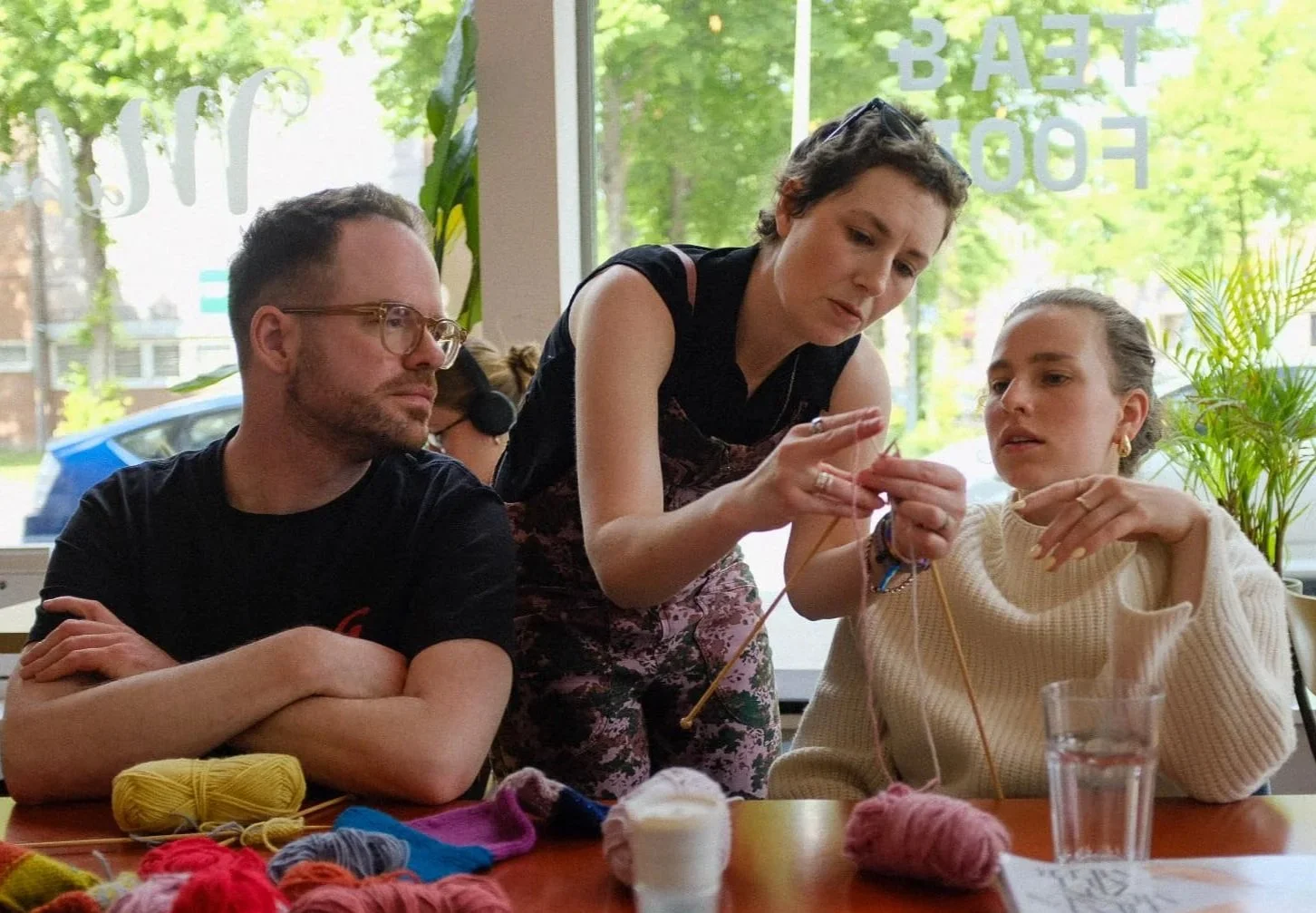 Knitting Teacher Alice teaching beginner knitters in a cafe