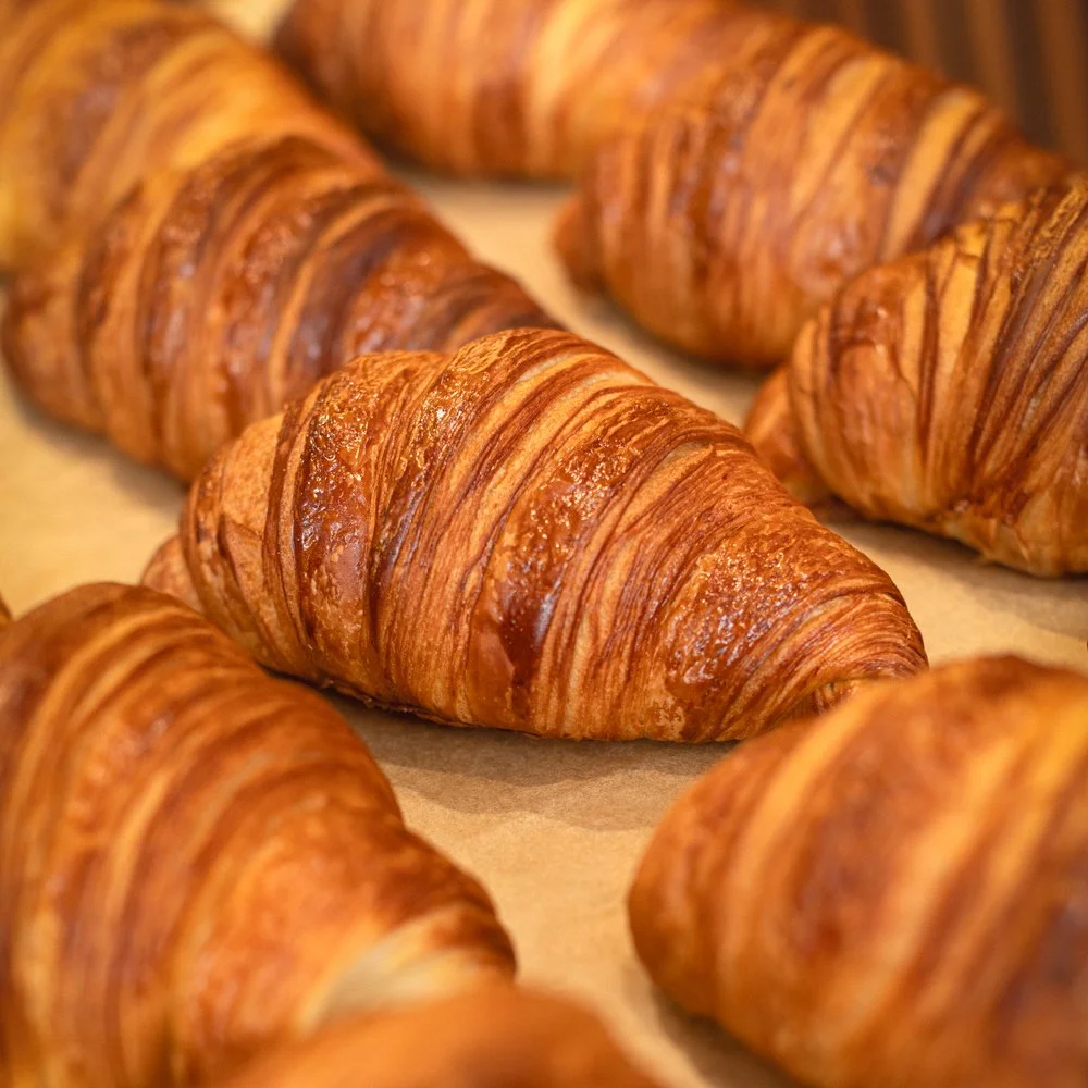 Freshly baked croissants on a baking sheet.