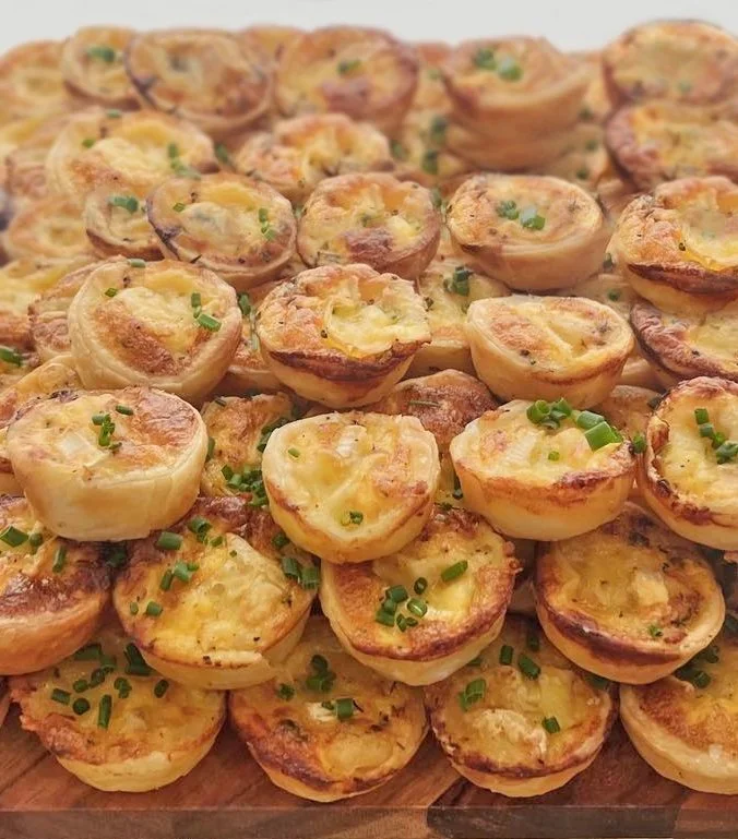 A large tray of baked egg muffins topped with chopped green onions.