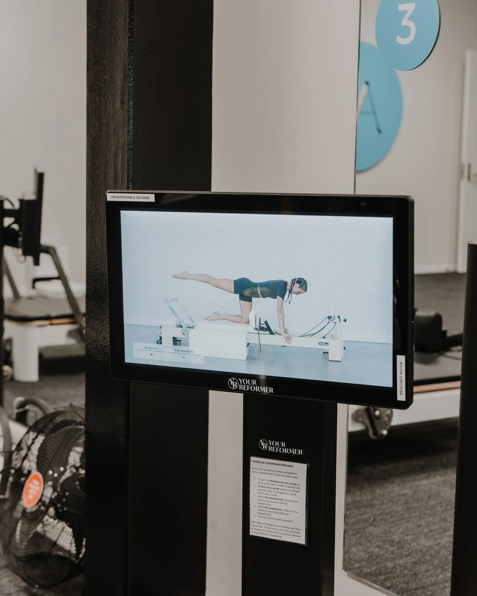 instructor doing pilates on kiosk screen
