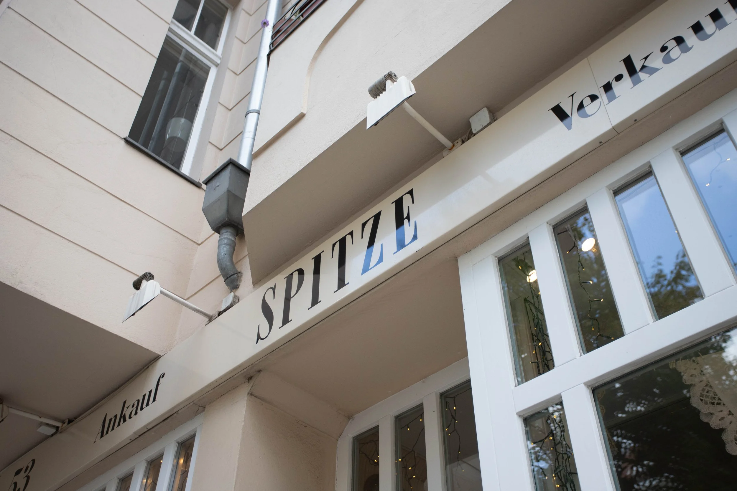 Außenansicht eines Gebäudes mit dem Schriftzug 'SPIITZE' und weiteren Worten, die teilweise sichtbar sind, darunter 'Ankauf'.