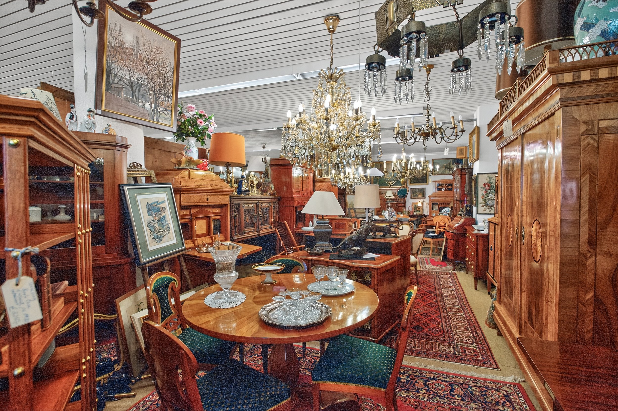 Ein Raum voller antiker Möbel, Gemälde, Kronleuchter und Dekorationsgegenstände.