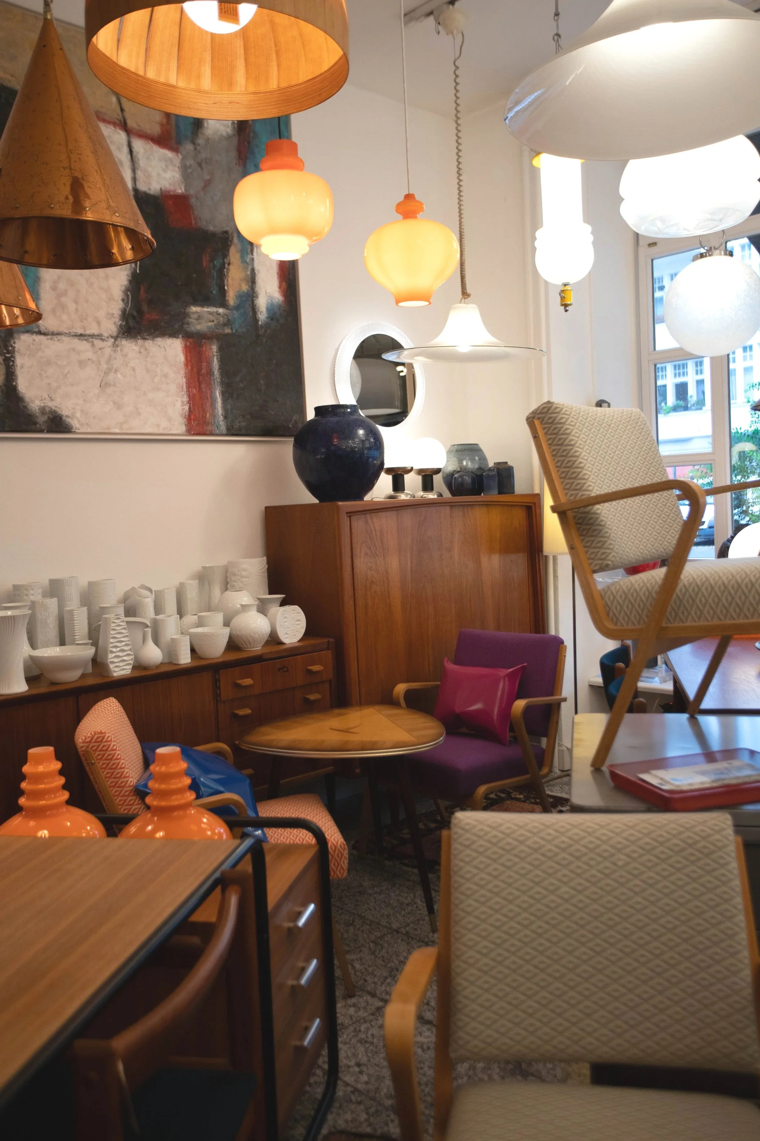 Innenraum eines Möbelgeschäfts mit verschiedenen Lampen, Vasen, Stühlen und Tischen.