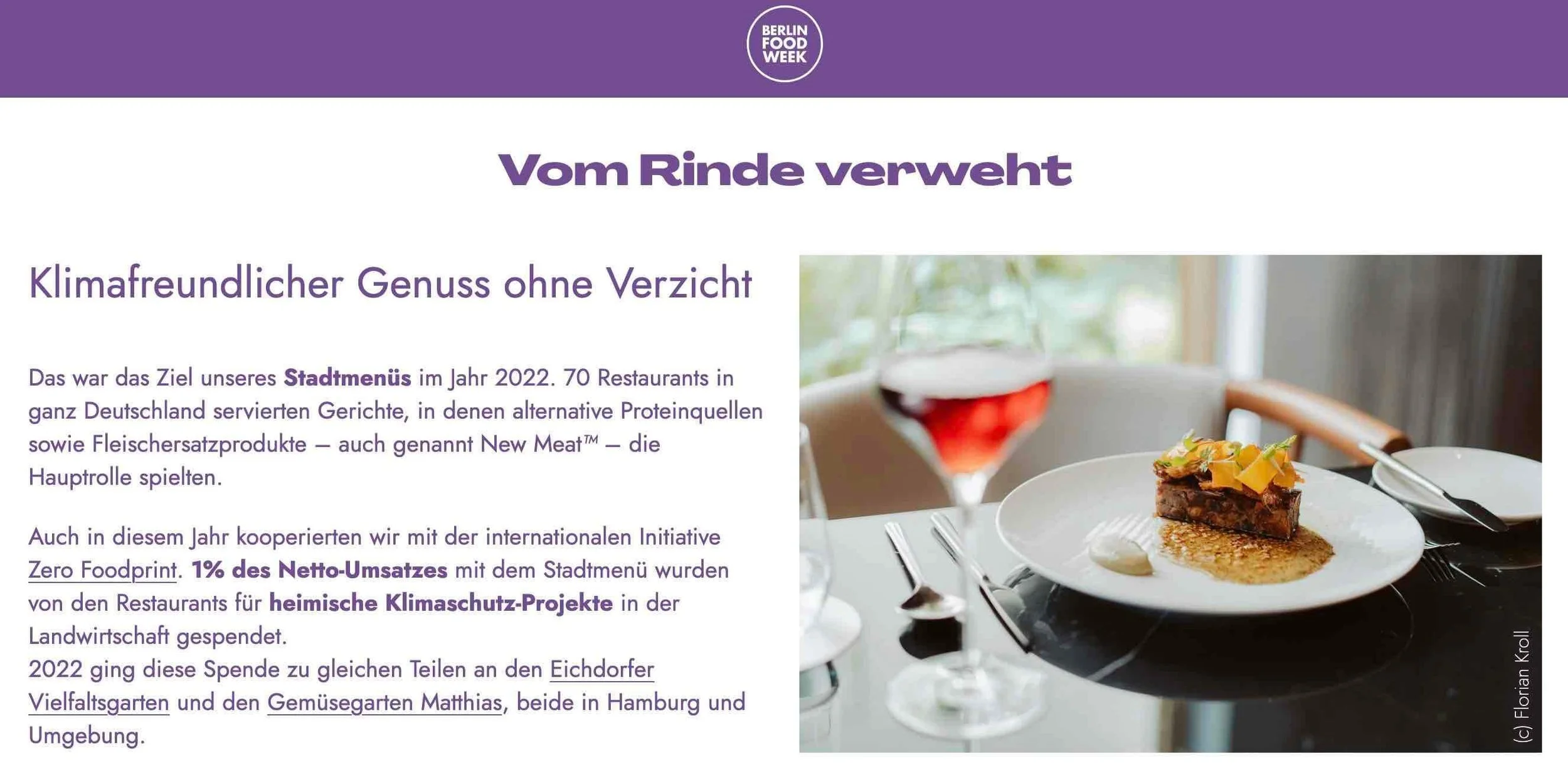 Ein Teller mit vegetarischem Fleischersatzgericht, daneben ein Glas roten Weins auf einem weißen Tisch, im Hintergrund ein Fenster mit natürlichem Licht.