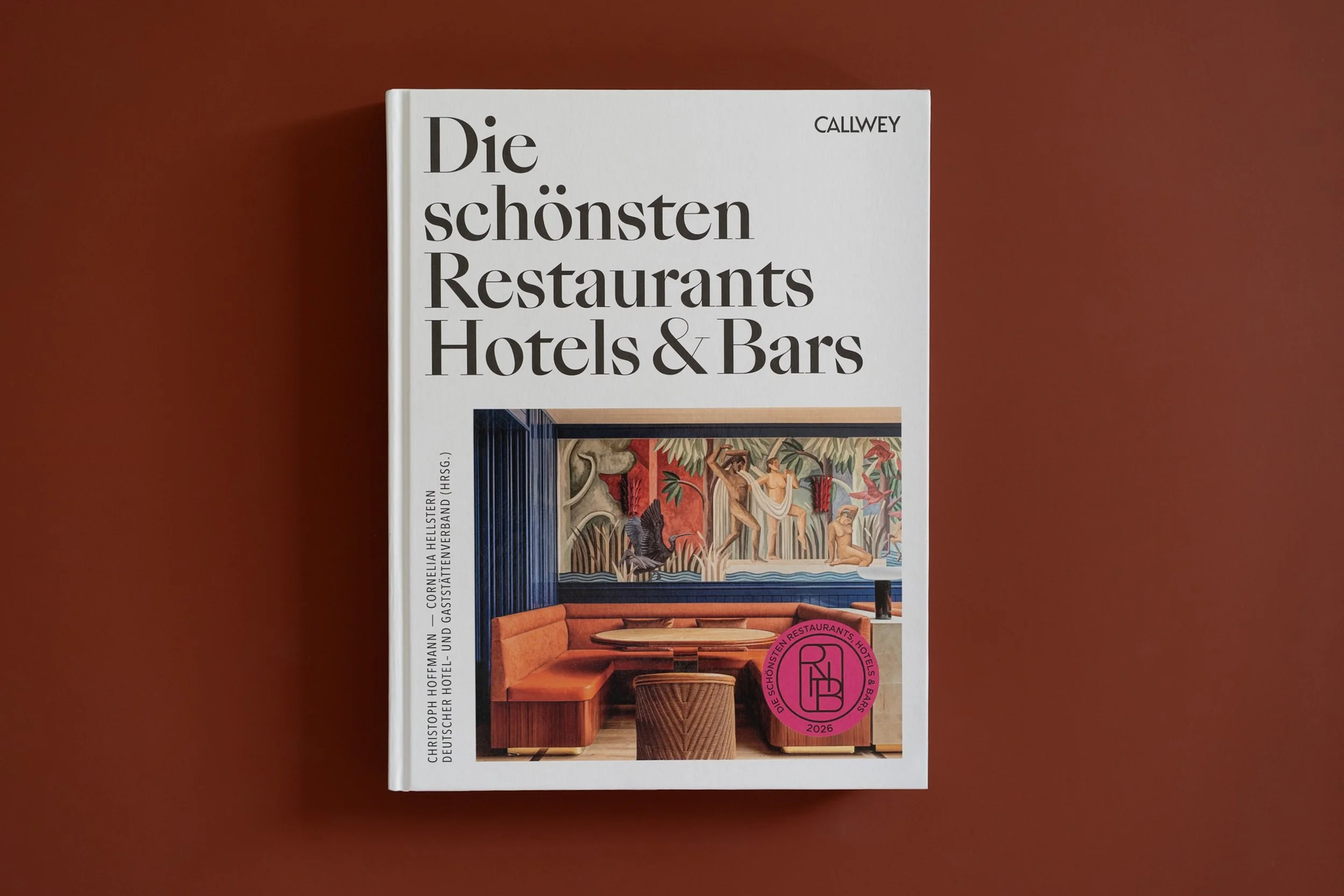 Buch mit dem Titel "Die schönsten Restaurants Hotels & Bars" auf einem terrakottafarbenen Hintergrund.