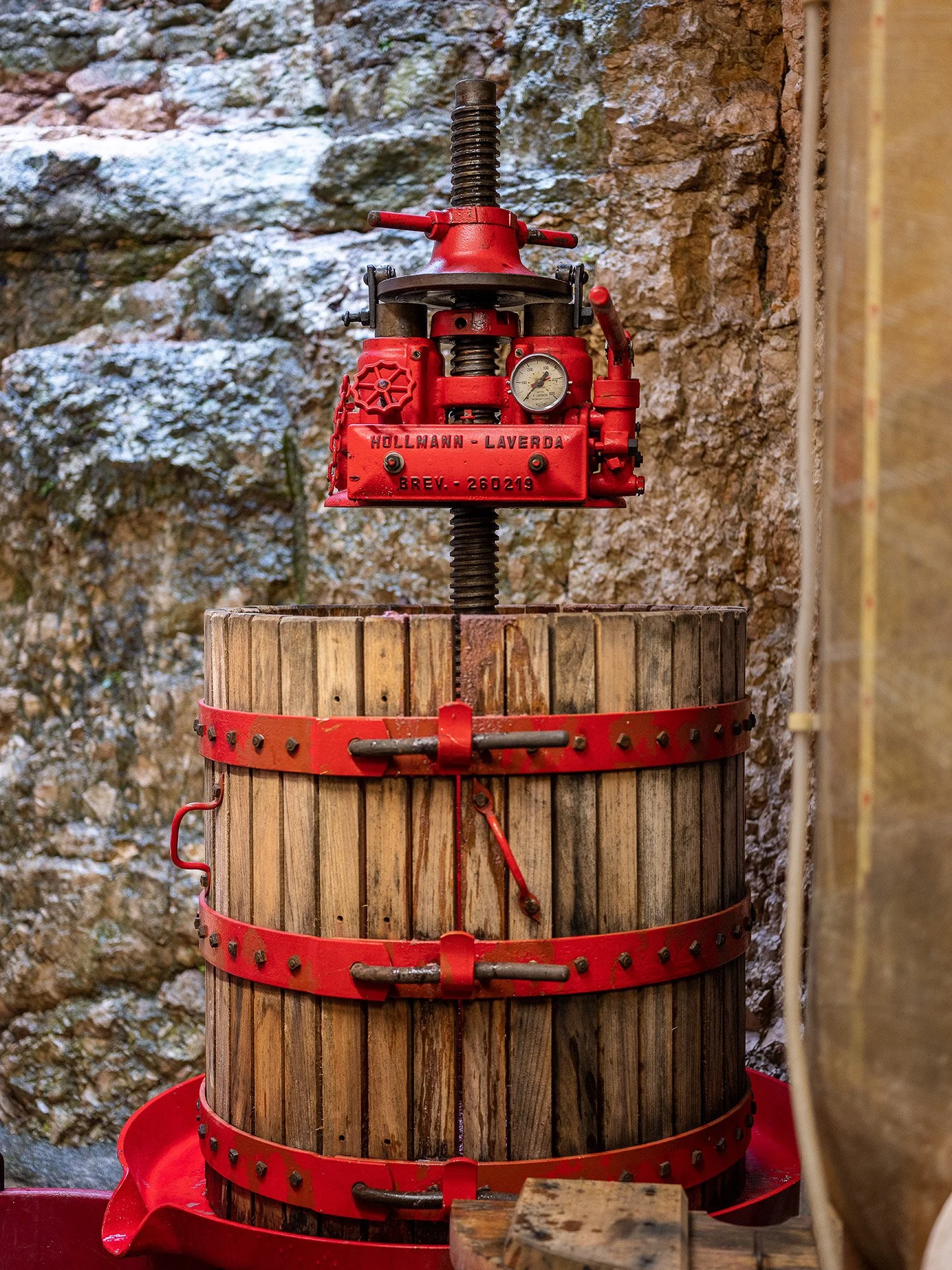 Un torchio di vinificazione su un tavolo di legno, con sfondo di rocce
