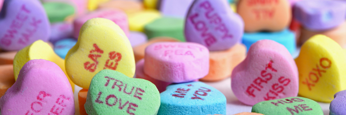 Close up of a pile of multicoloured Love Hearts sweets.