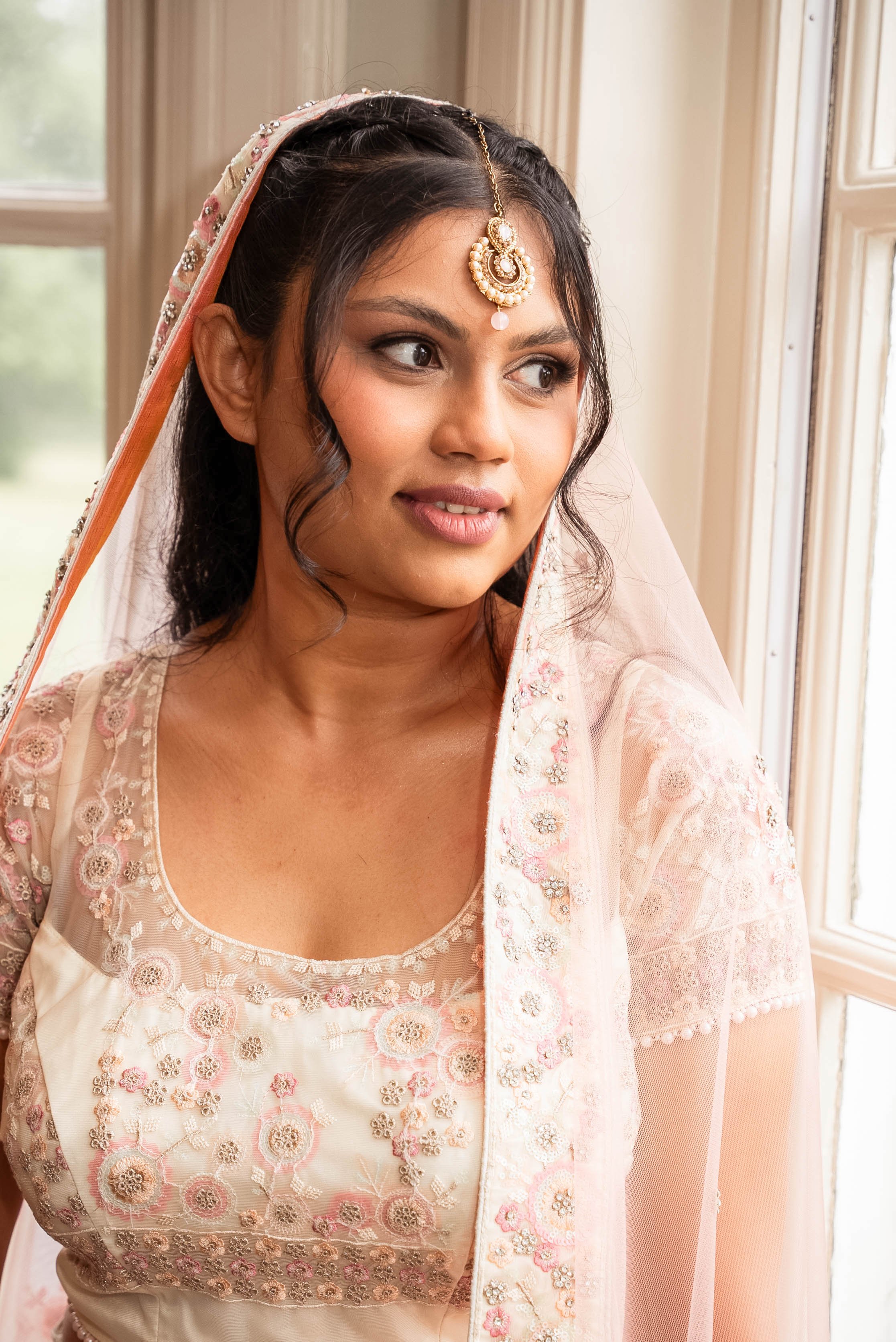 Woman in traditional attire looking out a window