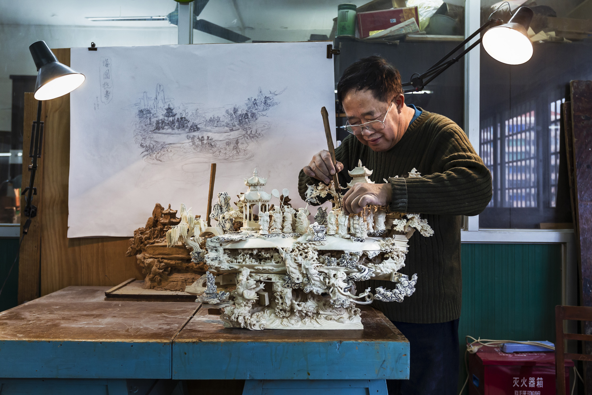 GUANGZHOU, CHINA, FEBRUARY 2012: Images of ivory carver Wu Rong Chang, 67, who has been carving for 50 years, photographed working on a large Ivory carving at the Guangzhou Daxin Ivory Carving Factory, the only state owned enterprise specialising in