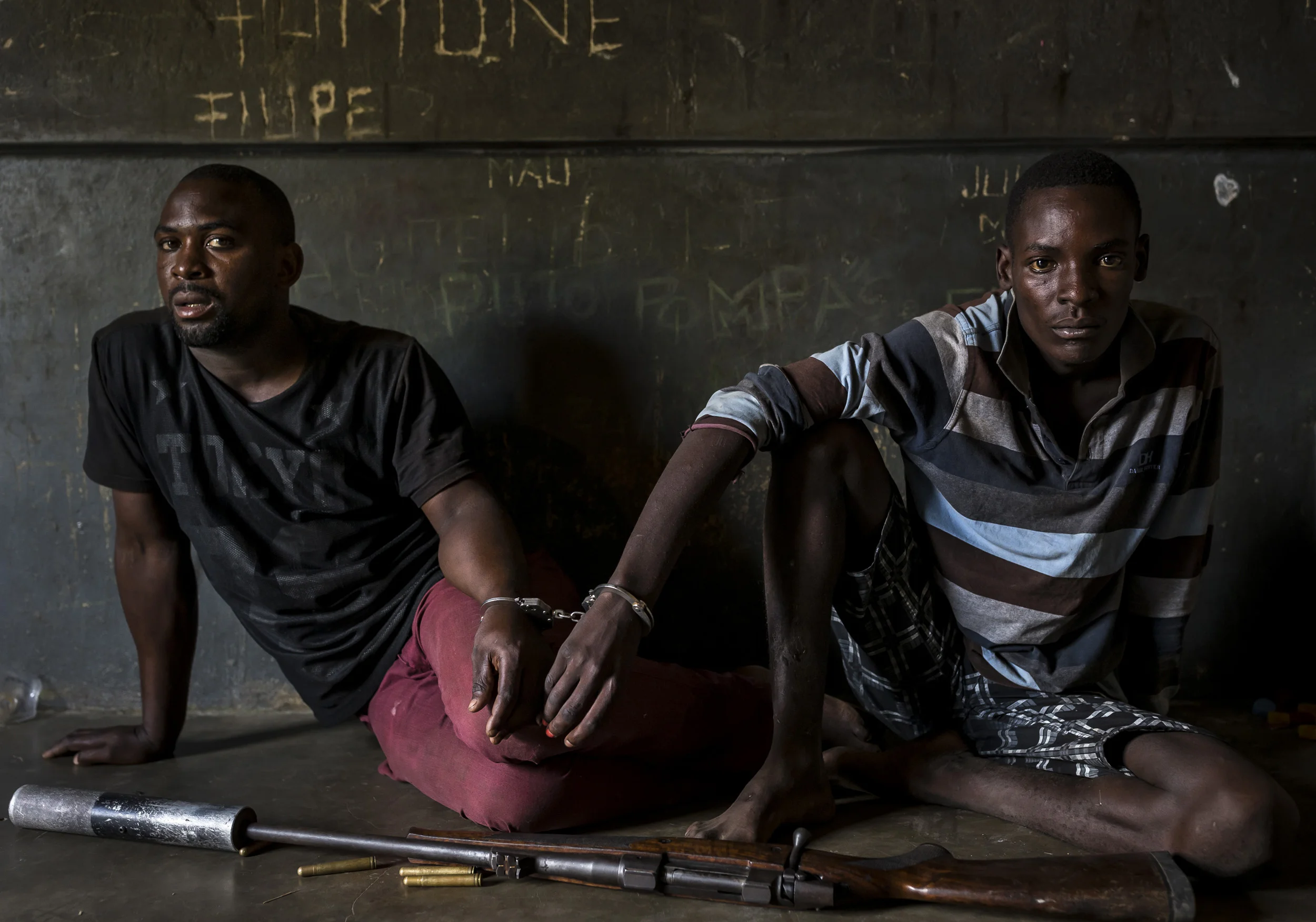 MOAMBA, MOZAMBIQUE, 19 APRIL 2016: Two rhino poachers, one 19, the other 28 years old, apprehended by an anti-poaching team in Mozambique close to Kruger National Park border. They are seen waiting to be processed in the local jail. After a three da