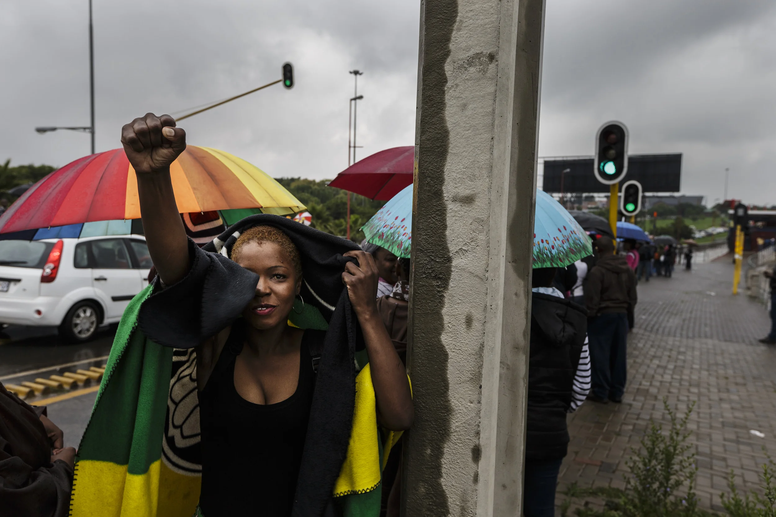 SOWETO, SOUTH AFRICA, 10 DECEMBER 2013: Mandela supporters wait for public transport in the rain on their way to FNB stadium for a day of comemoration for Nelson Mandela, the iconic Freedom Fighter of the ANC, Soweto, South Africa, 10 December 2013.